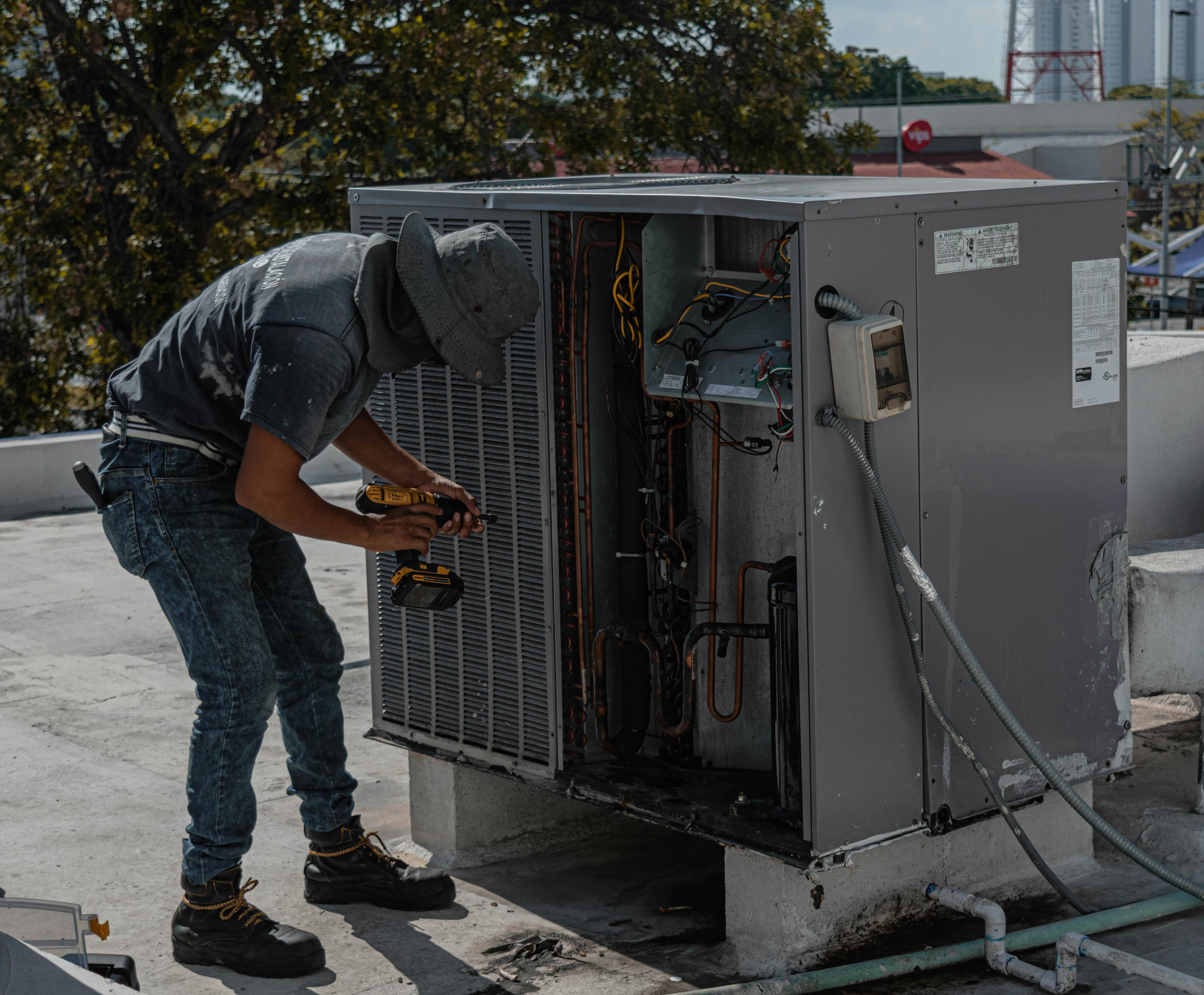 HVAC technician servicing air conditioning unit