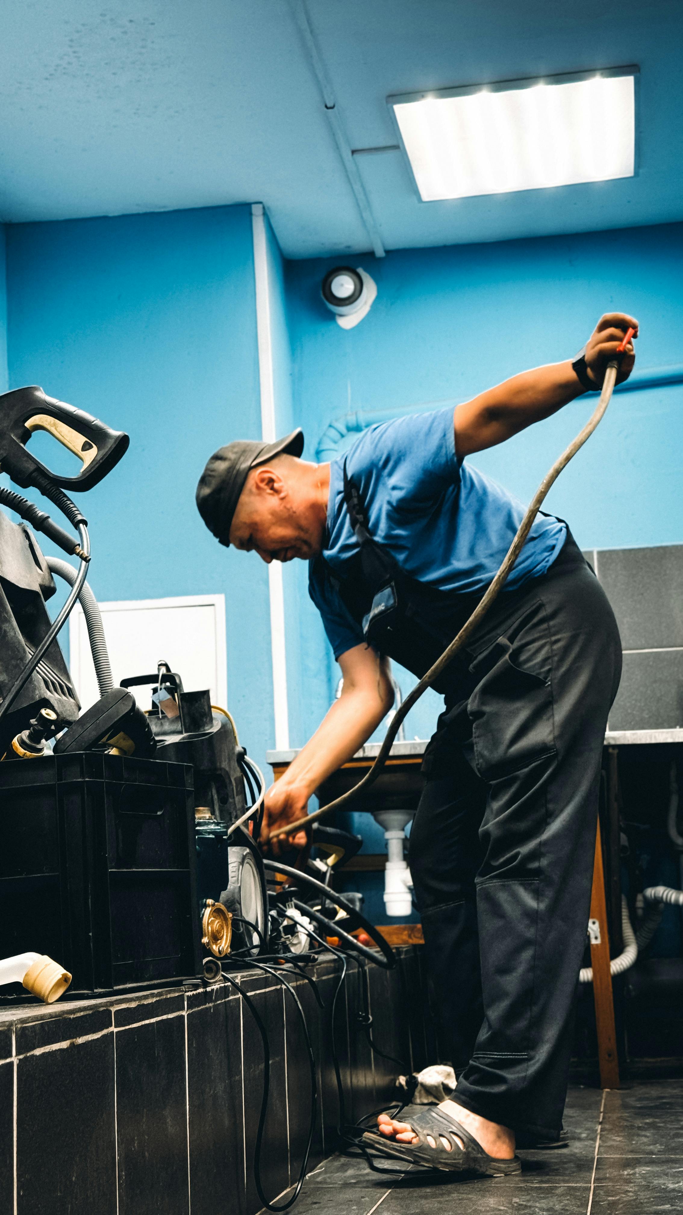 Professional plumber working on plumbing system